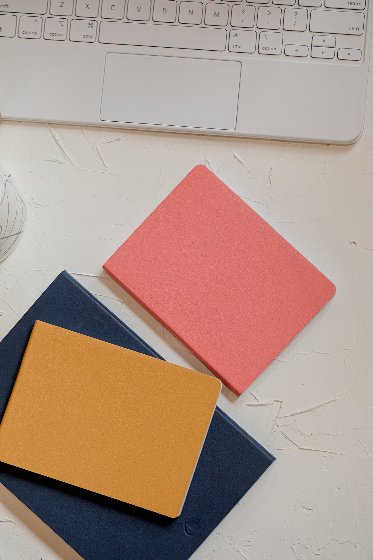 Flatlay of a pink notebook on a wooden desk